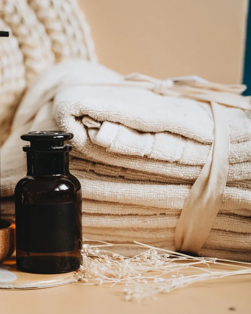 Massageöl und gefaltete Handtücher in der Praxis